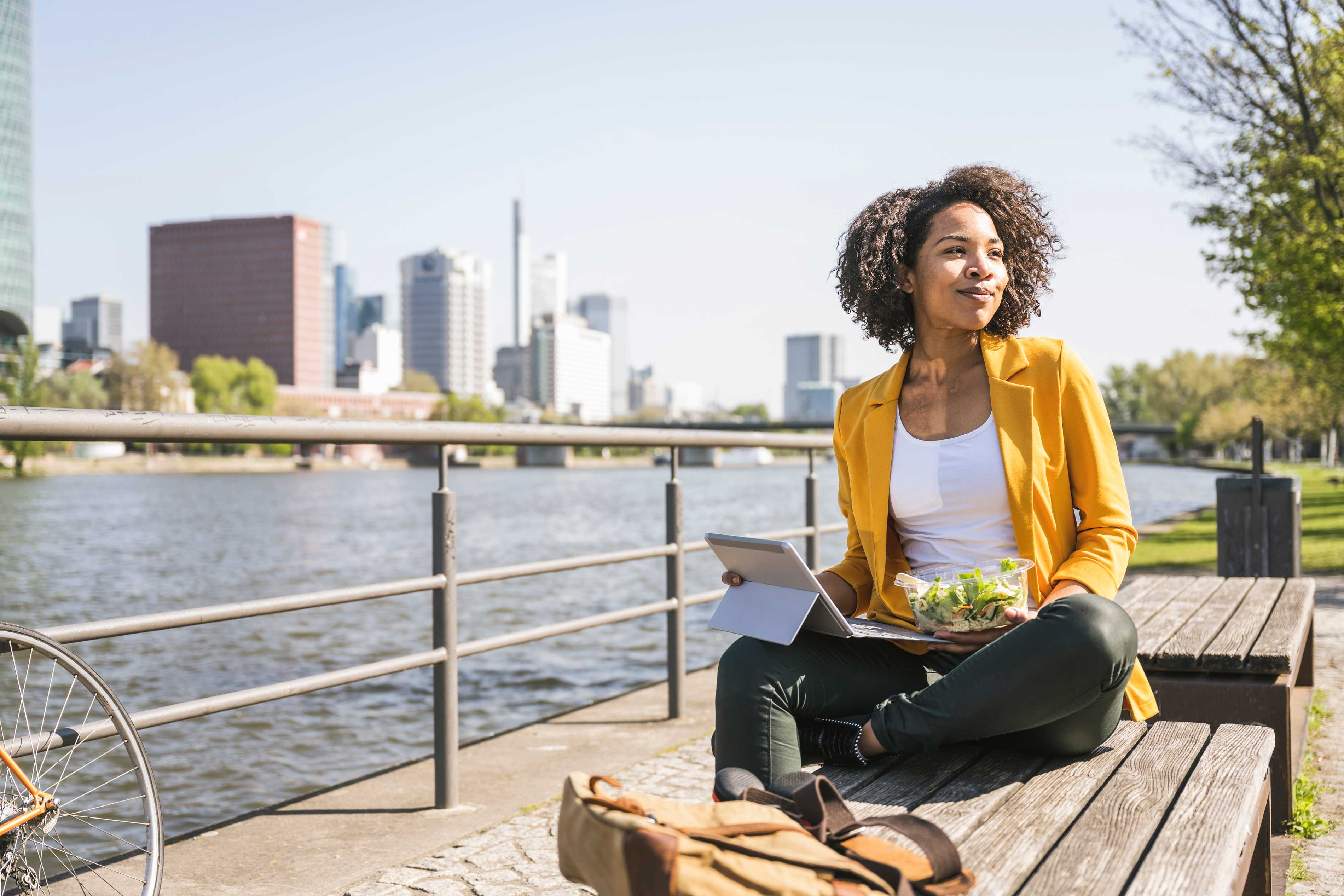 Stock photo  Relaxed woman working on laptop by river
